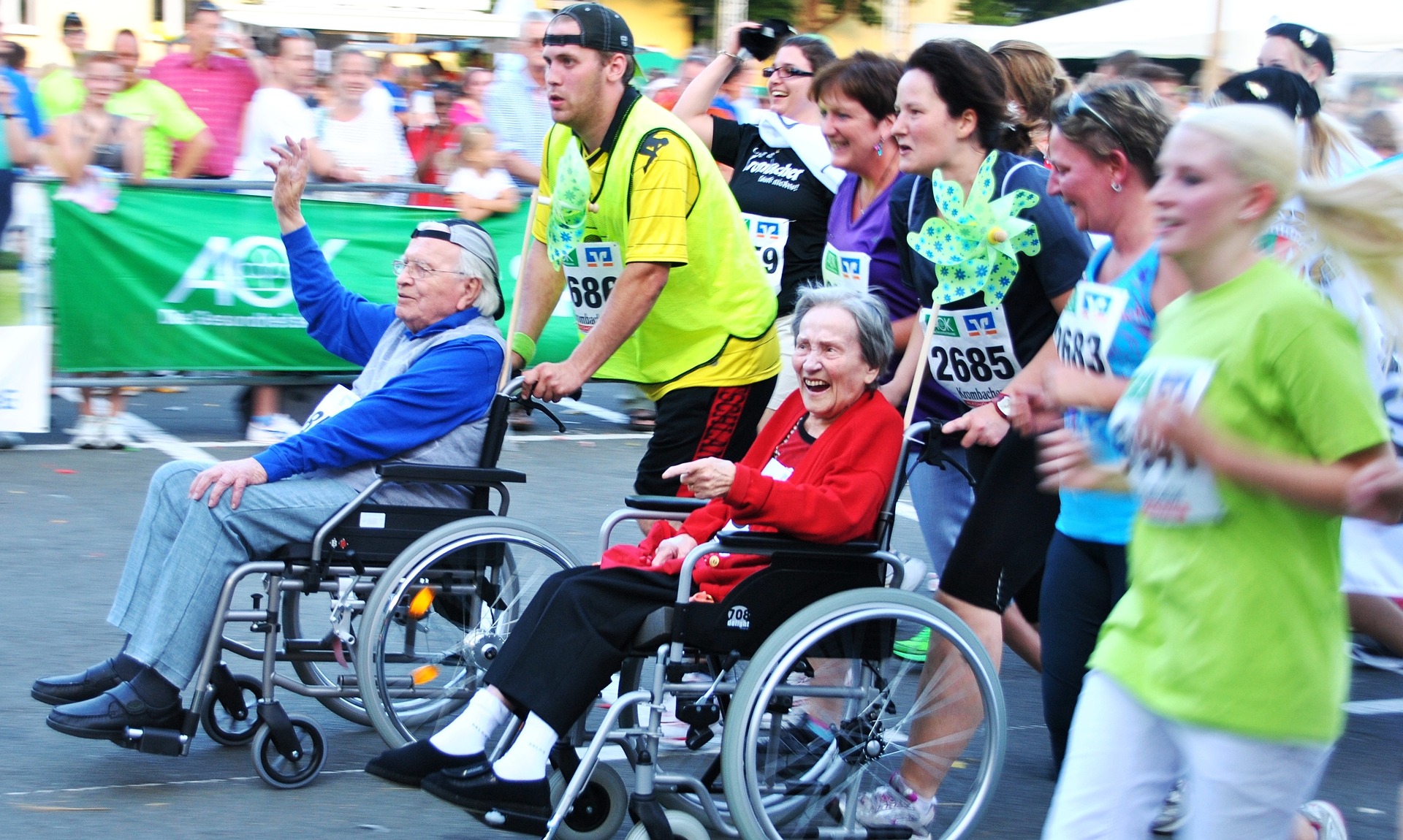 Volunteers pushing elderly in wheelchairs to the finish line