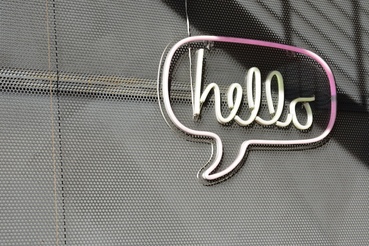 Pink sign on a wall that says
