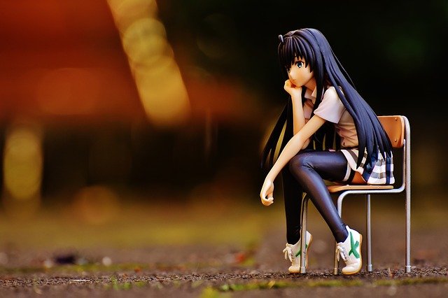 female anime figure sitting in chair thinking
