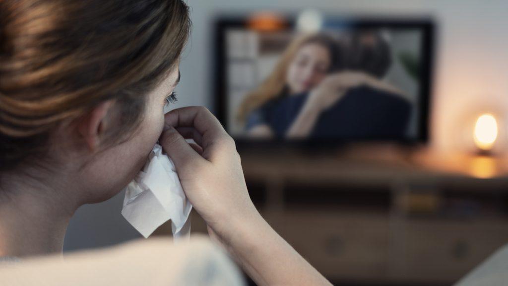 woman crying while watching tv